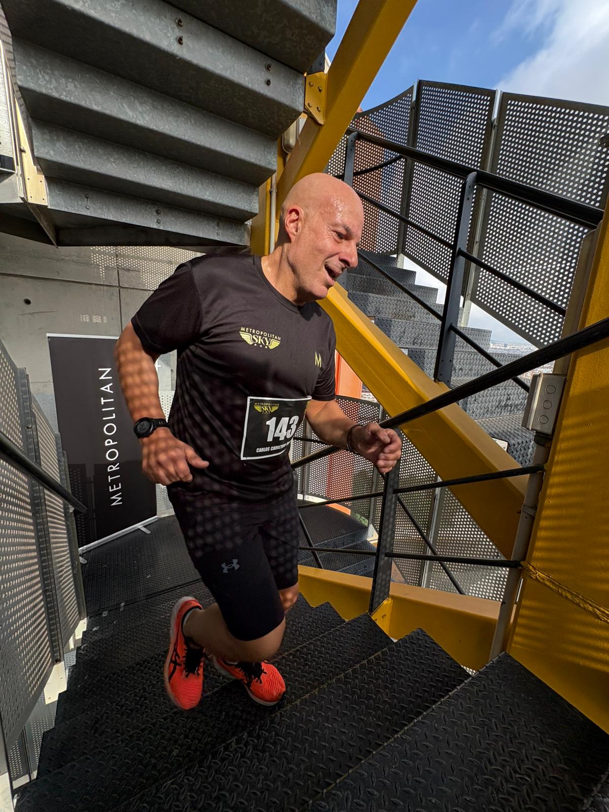 Bombero celebra en meta con cronómetro visible en la Metropolitan Sky Run 2025
